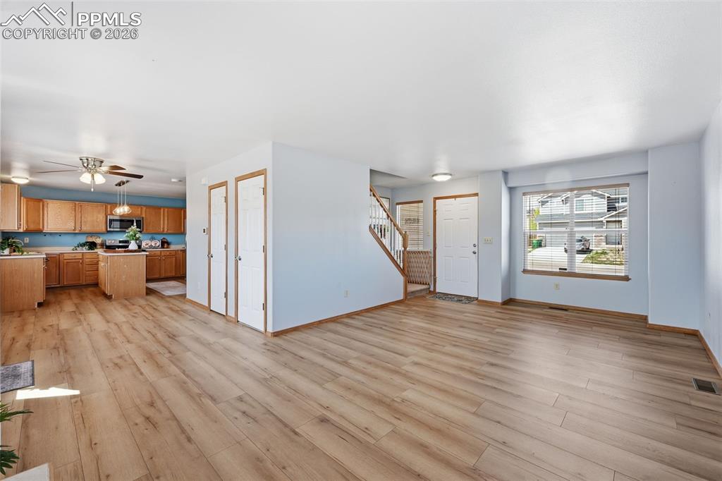 Image 6 of 42: Living room opens to dining area and into kitchen