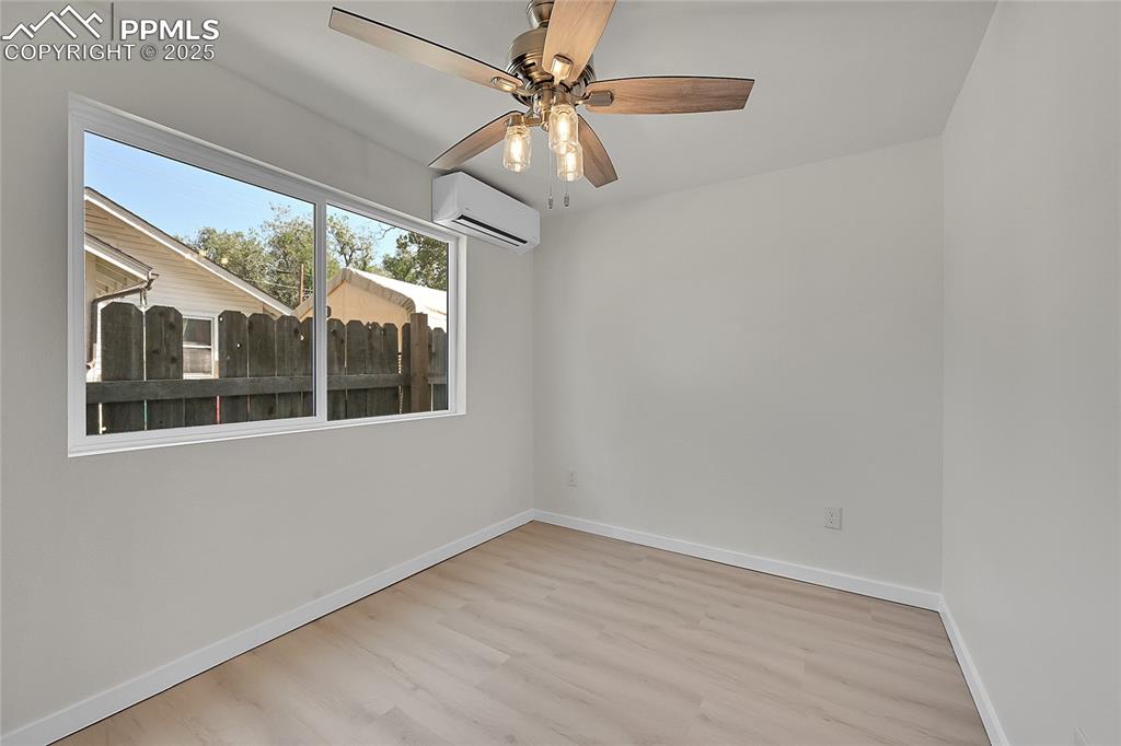 Image 15 of 30: Unfurnished room with light wood finished floors, a wall unit AC, and ceili