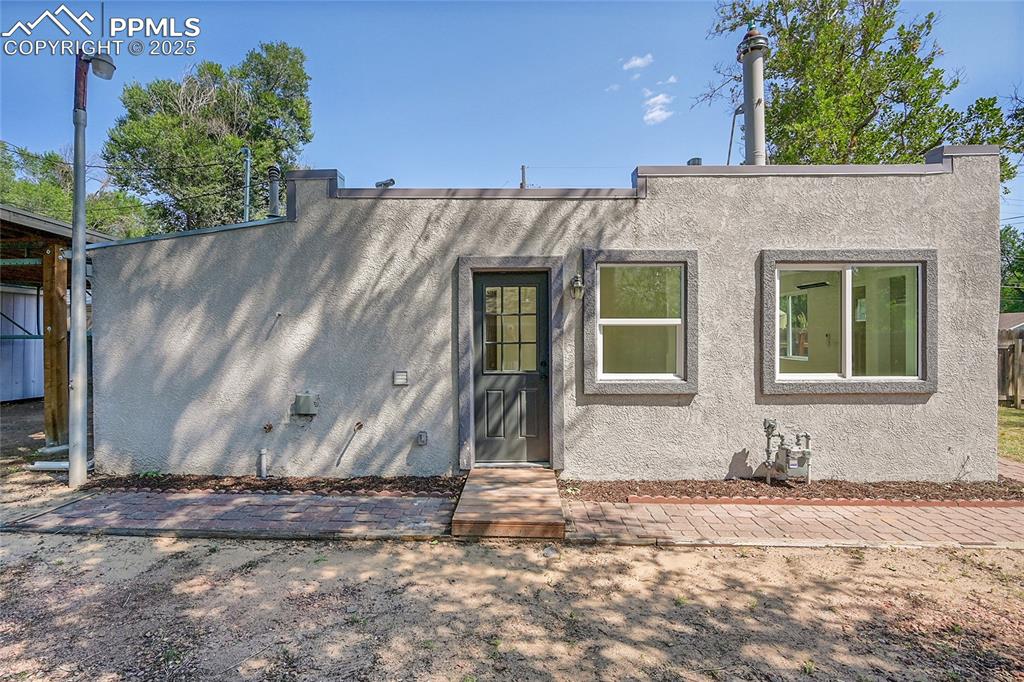 Image 23 of 30: View of front of house with stucco siding