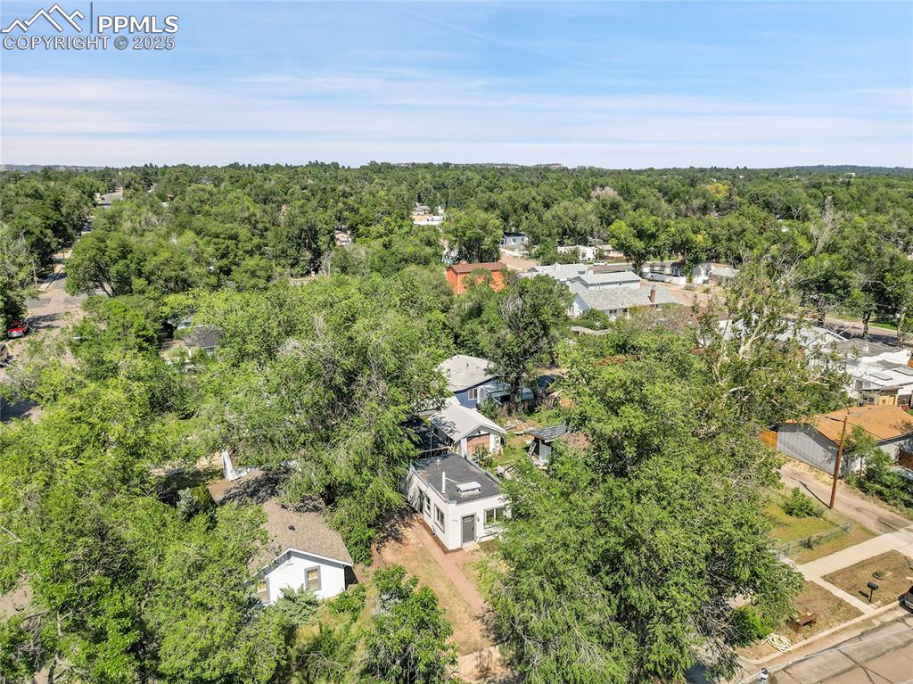 Image 28 of 30: Aerial view of residential area featuring a heavily wooded area