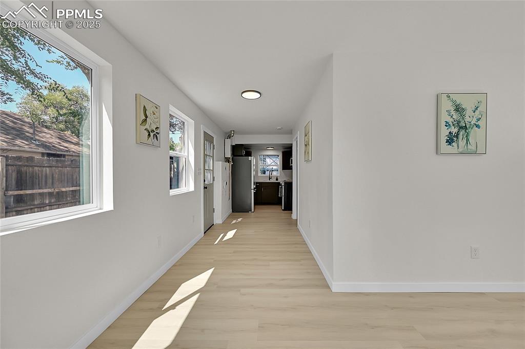 Image 9 of 30: Hall with baseboards and light wood-style flooring