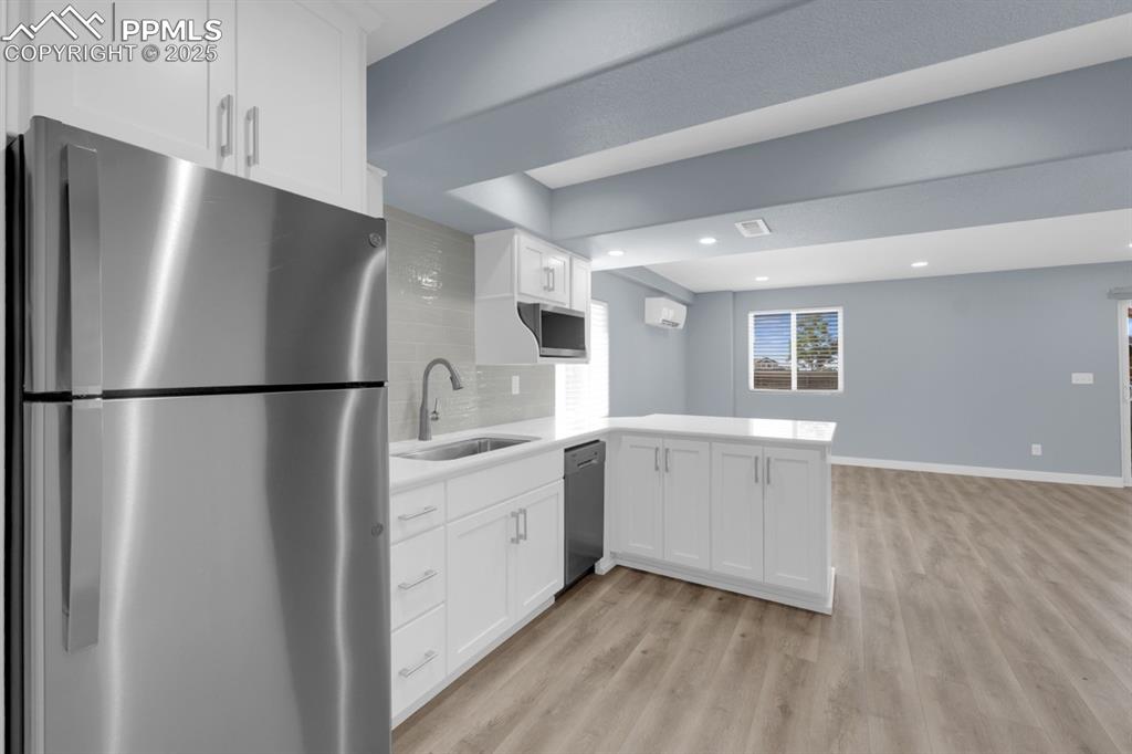 Image 22 of 40: Basement Kitchenette leading to Basement Living Room