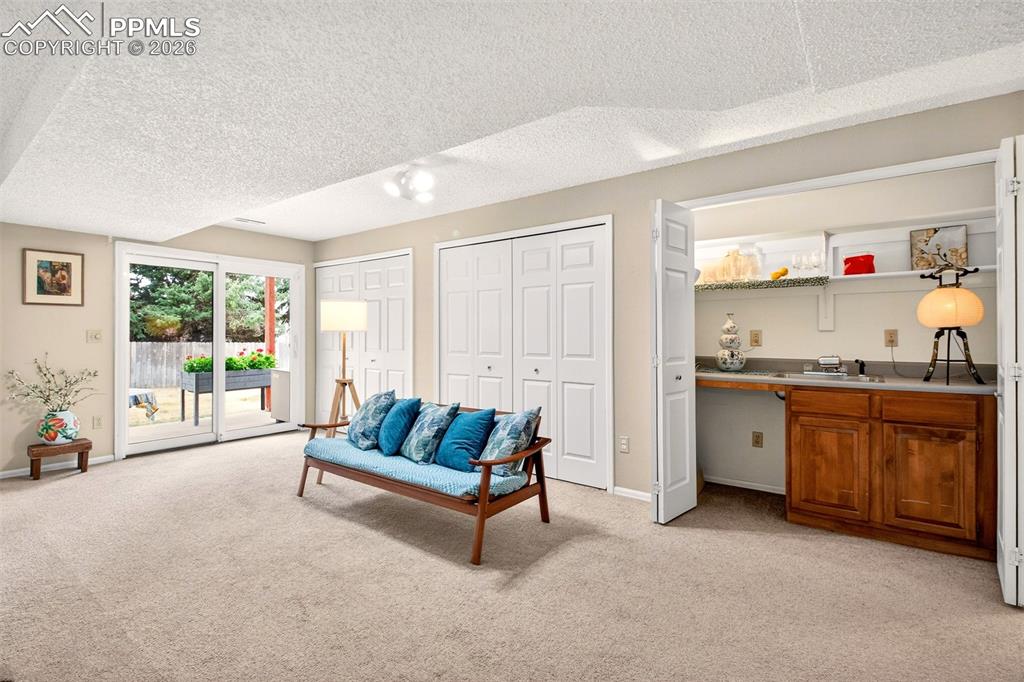 Image 23 of 36: Spacious basement family room offering an abundance of strorage and a wet b