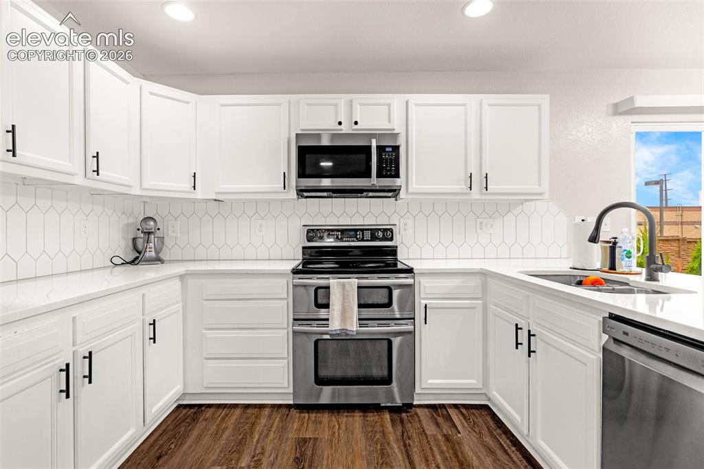 Image 11 of 35: Kitchen featuring white shaker-style cabinetry, stainless steel appliances,
