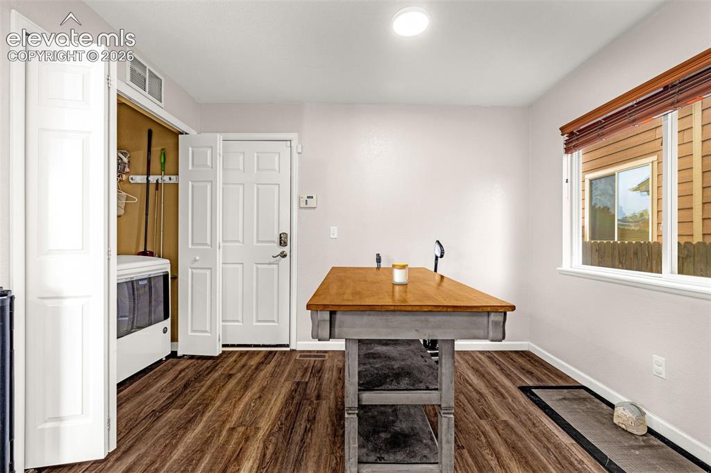 Image 14 of 35: Laundry area with wood-finish flooring, recessed ceiling lighting, and a bi