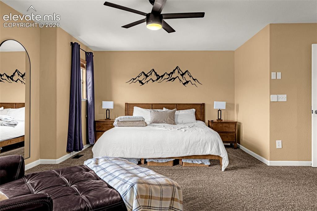 Image 18 of 35: Spacious room featuring neutral wall paint, carpeting, an arched floor mirr