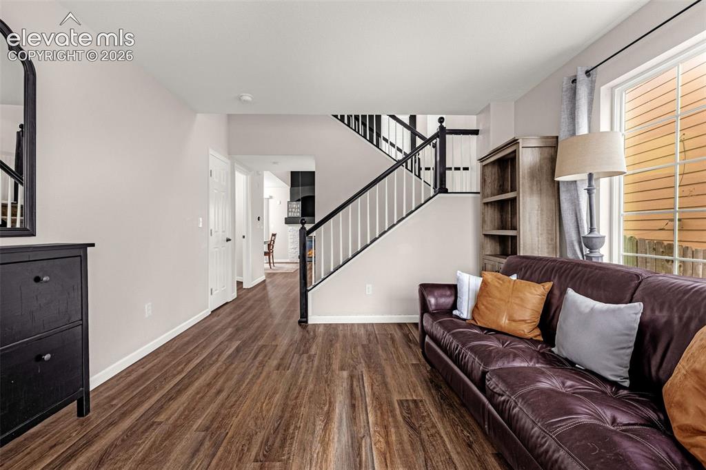 Image 2 of 35: Interior space featuring wood-finish flooring, a staircase with black raili