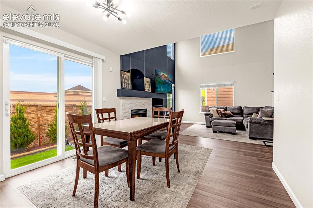Image 25 of 35: High ceilings, stone-surround fireplace, dark wood-finish flooring, sliding