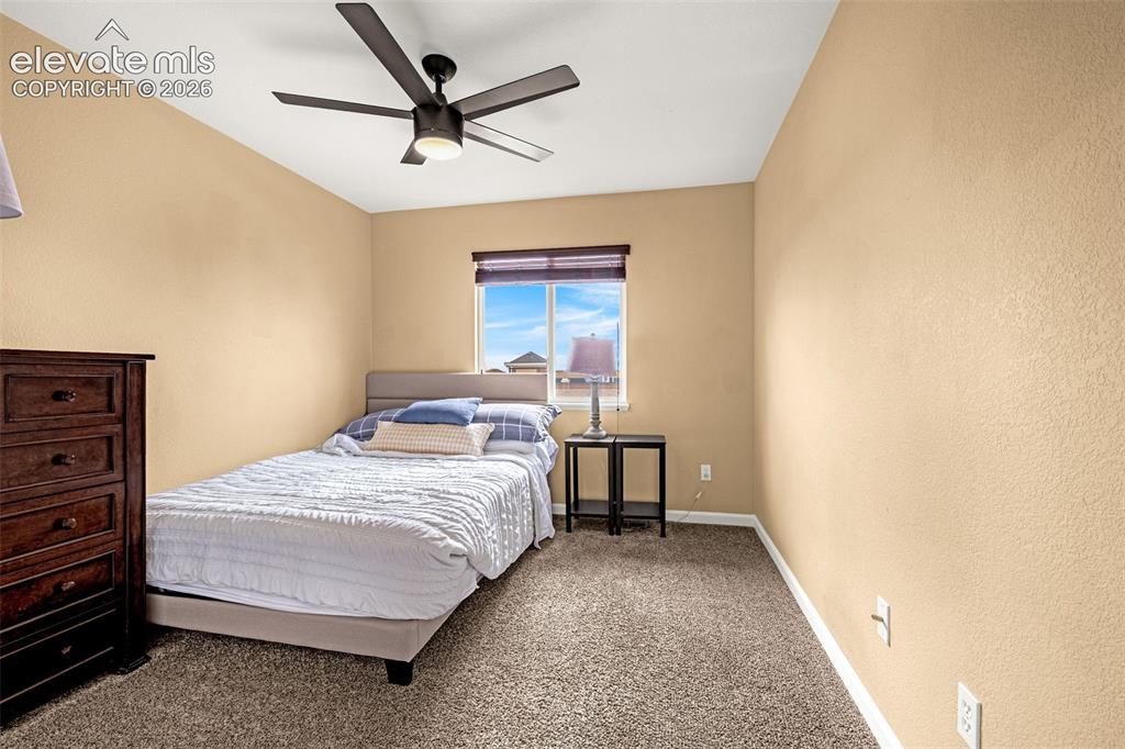 Image 27 of 35: Neutral-toned walls, textured carpet, and a matte-finish ceiling fan with i