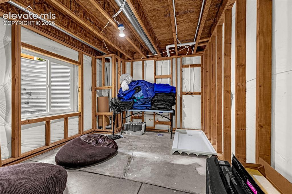 Image 28 of 35: Unfinished space featuring exposed timber framing, concrete flooring, an eg