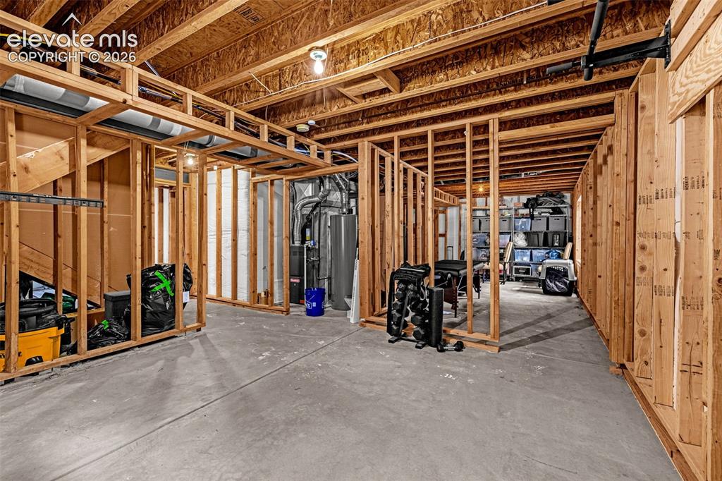Image 29 of 35: Unfinished basement area featuring exposed timber framing, concrete floorin
