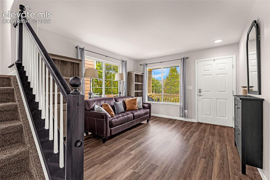 Image 3 of 35: Wood-finish flooring, staircase with a dark-stained wood handrail and white
