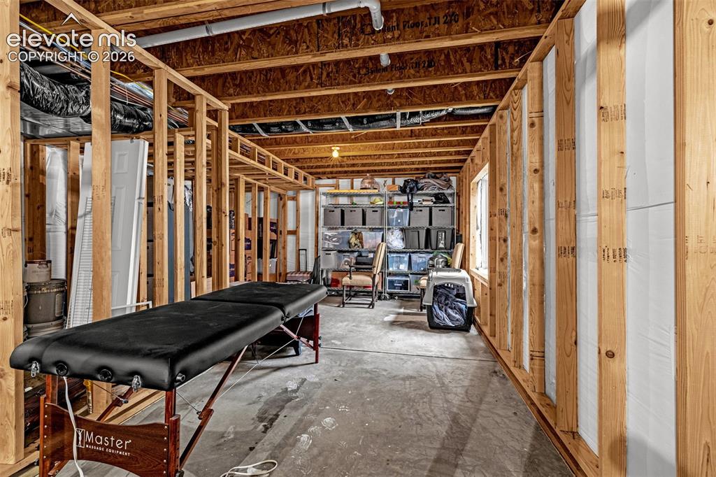 Image 30 of 35: Unfinished interior space featuring exposed wood-stud framing, exposed floo