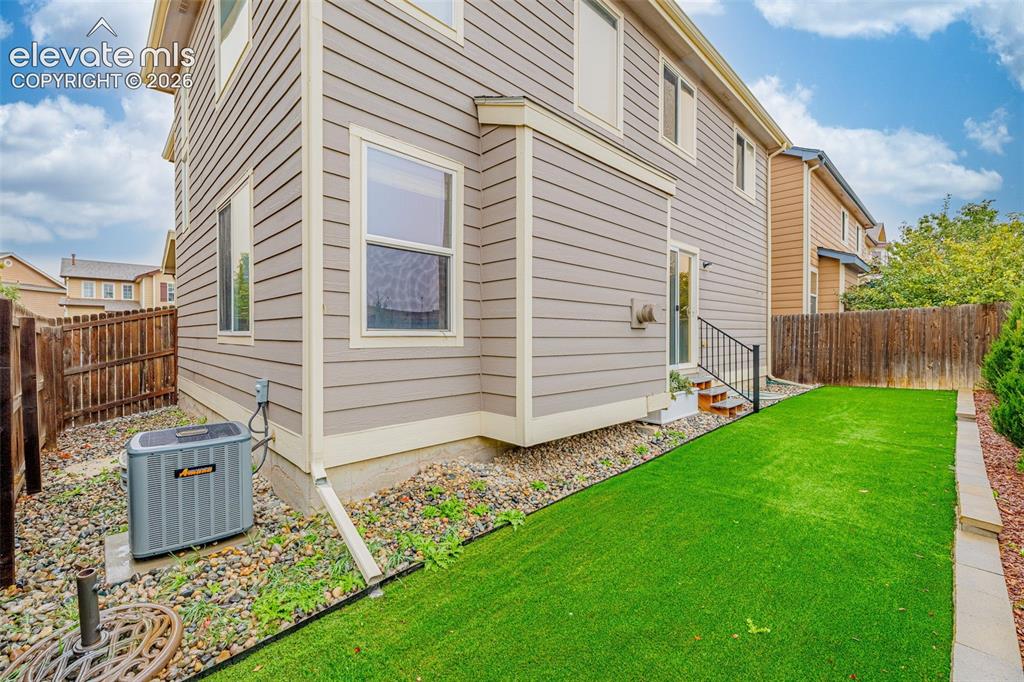 Image 32 of 35: Two-story horizontal lap siding exterior featuring a grass lawn, metal stai