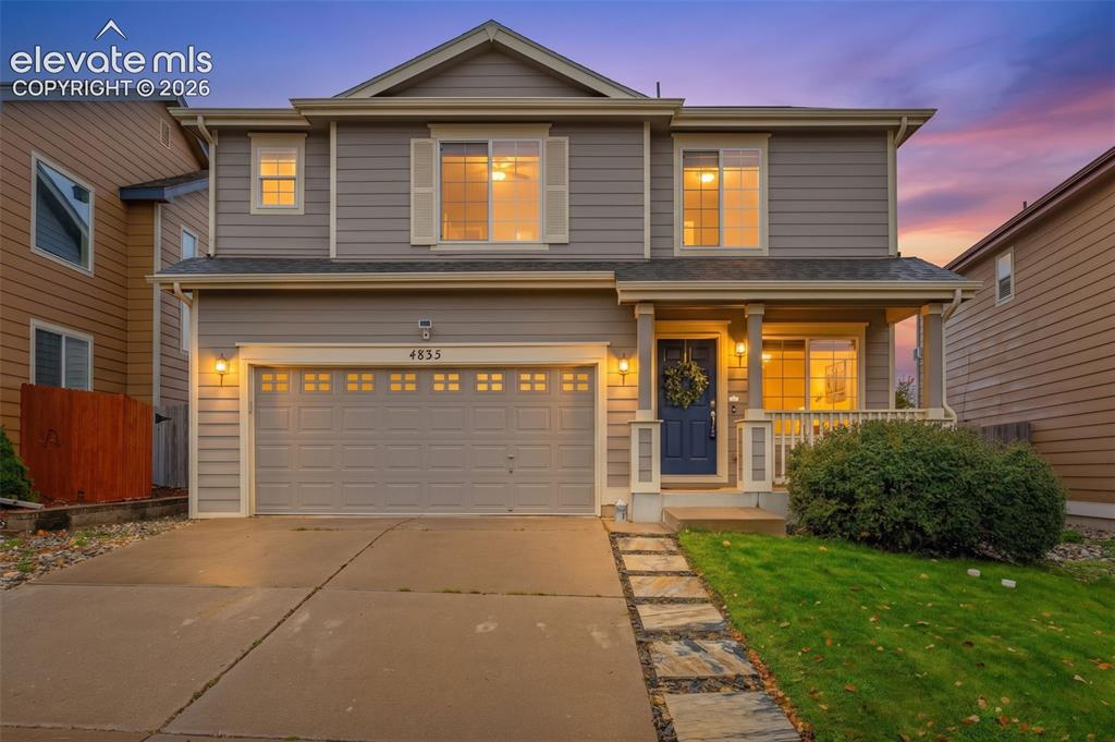 Image 33 of 35: Two-story residence featuring horizontal lap siding, a two-car garage with 