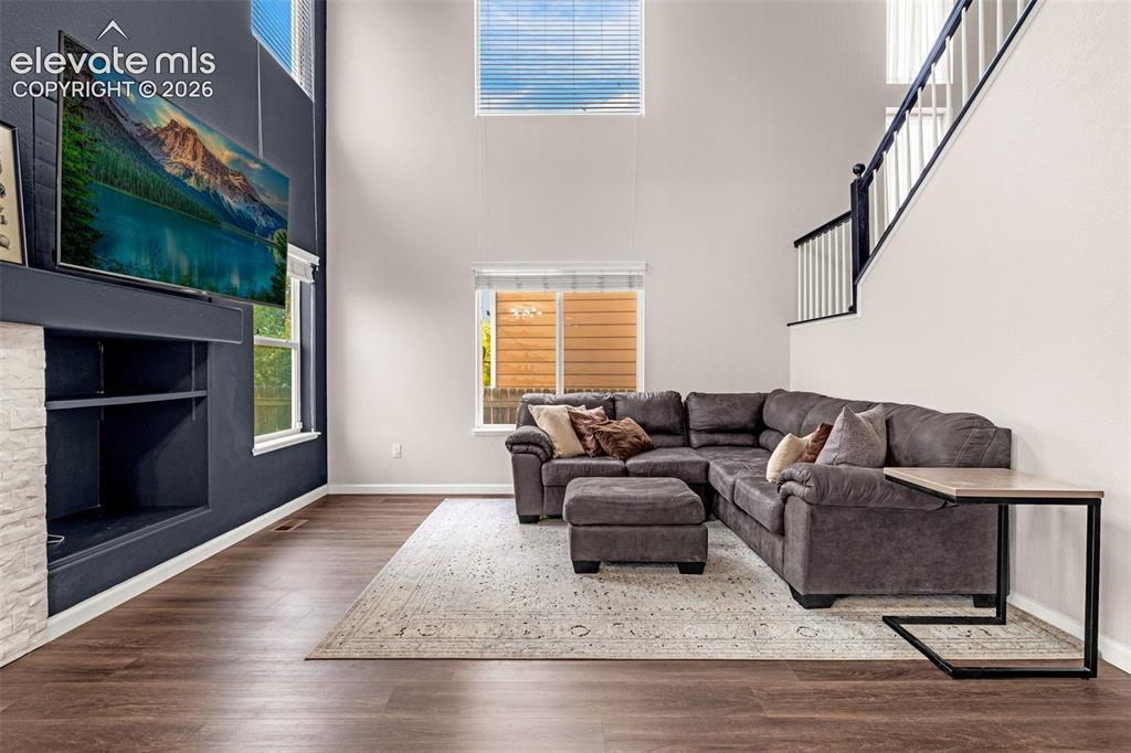 Image 6 of 35: Double-height ceiling, floor-to-ceiling accent wall, fireplace with white s