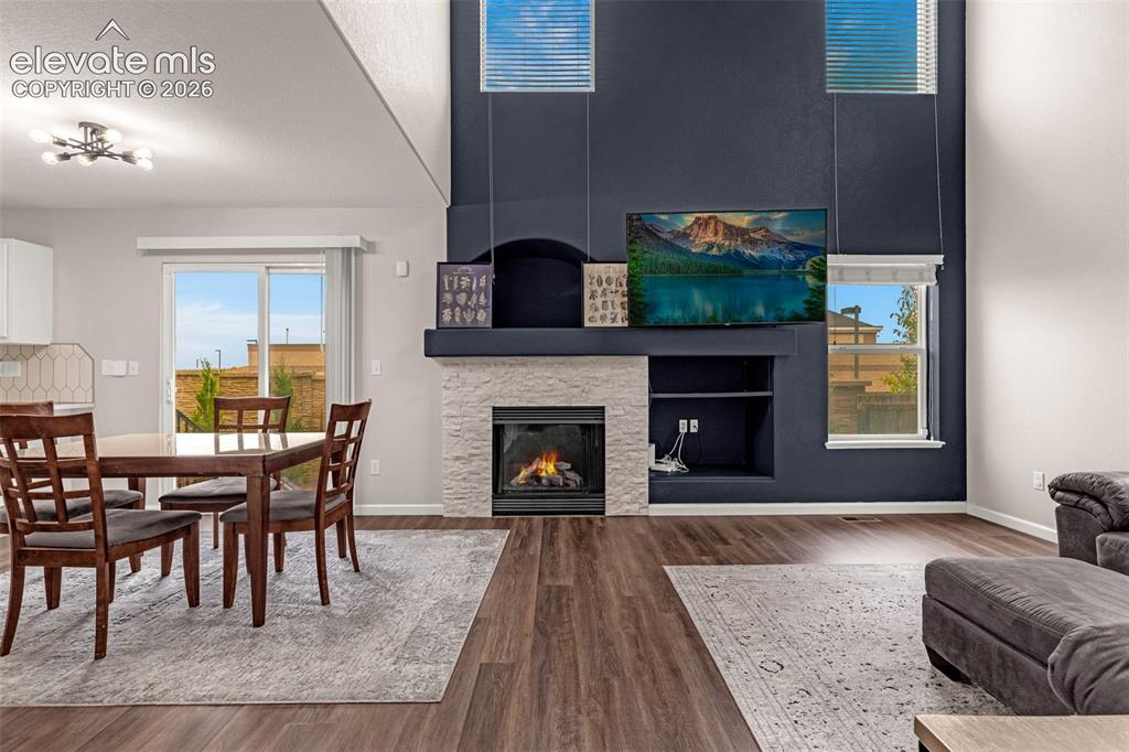 Image 7 of 35: Double-height ceiling, floor-to-ceiling accent wall, fireplace with stone-f