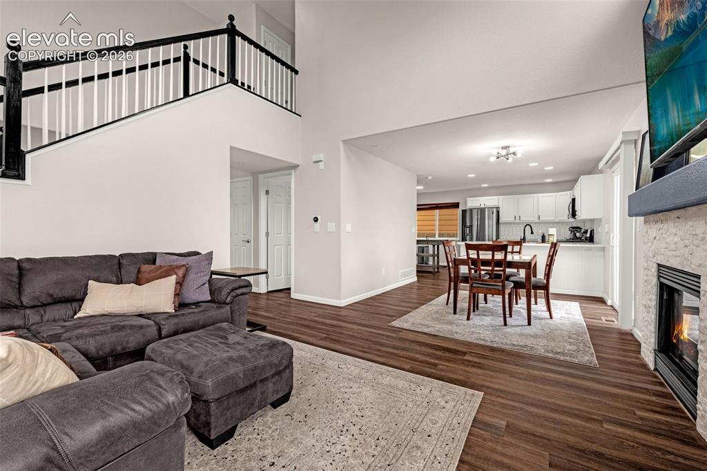 Image 8 of 35: Open-concept interior featuring wood-finish flooring, a two-story ceiling, 