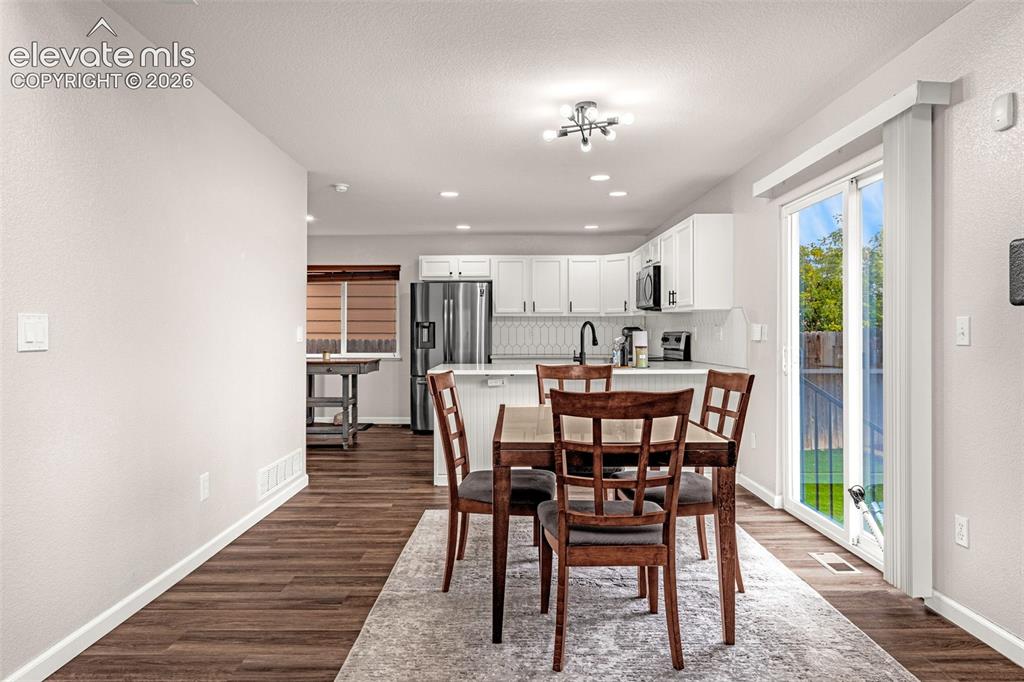 Image 9 of 35: Kitchen featuring white shaker-style cabinetry, stainless steel appliances,
