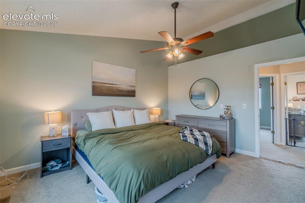 Image 13 of 31: Vaulted ceiling with an integrated ceiling fan, carpeted flooring, and a up