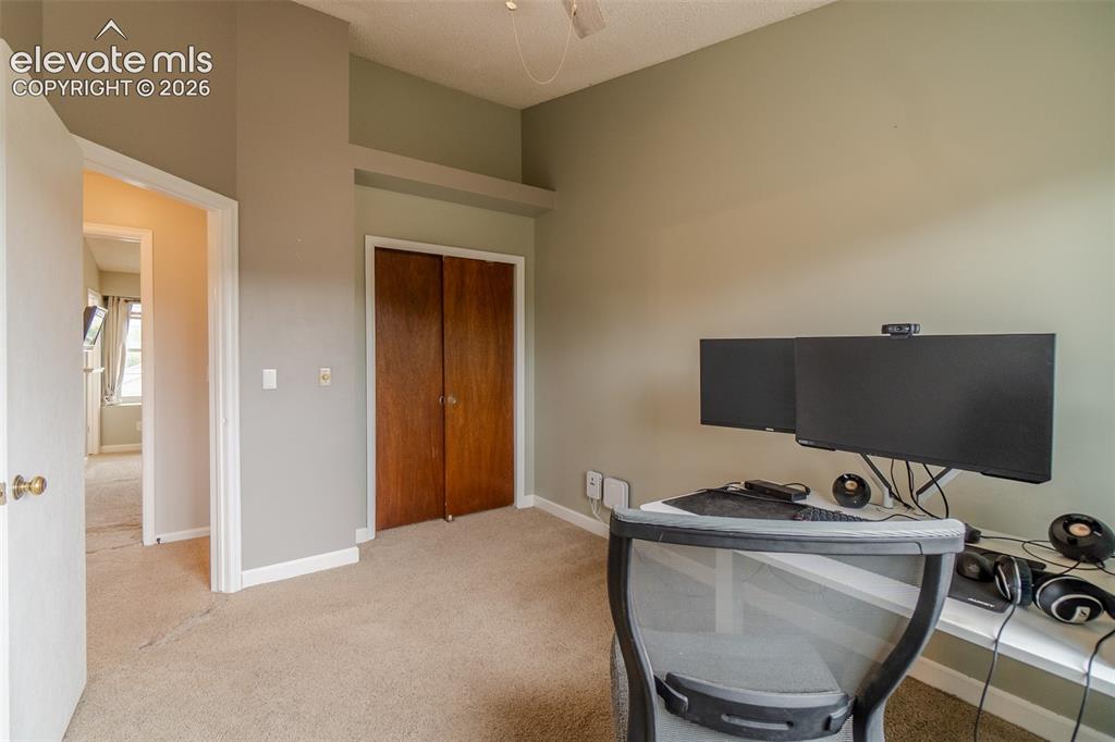 Image 18 of 31: Carpeted room with bi-fold wood doors and overhead architectural detail