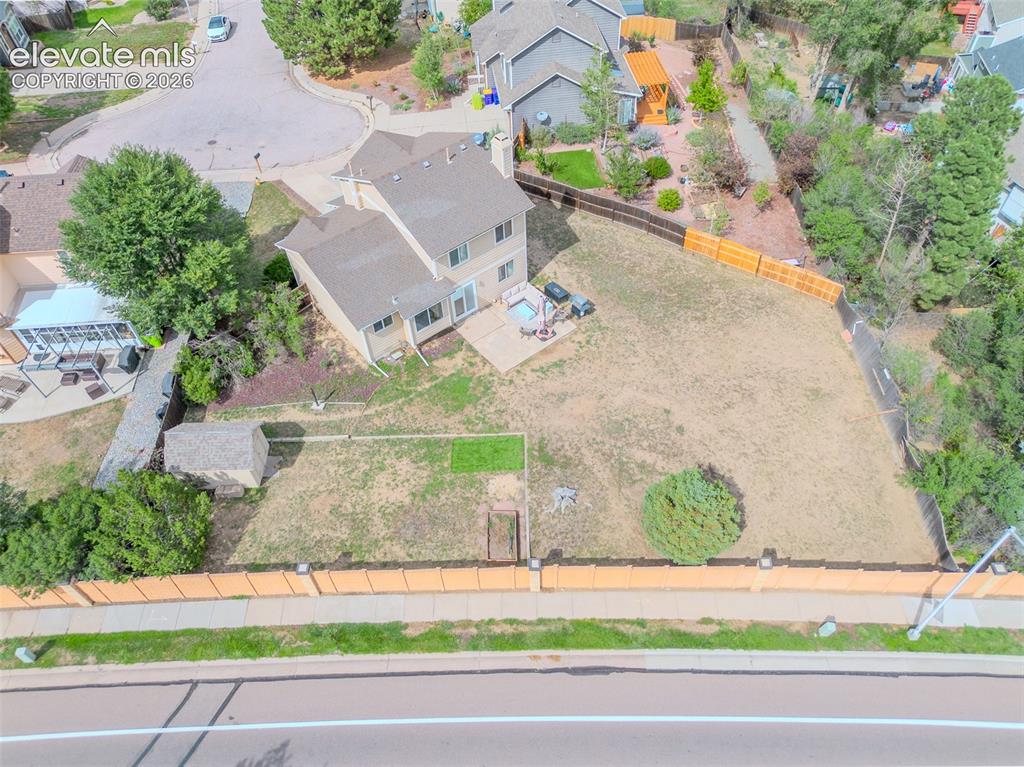 Image 24 of 31: Spacious 1/4 acre backyard featuring a multi-level deck, storage shed, and