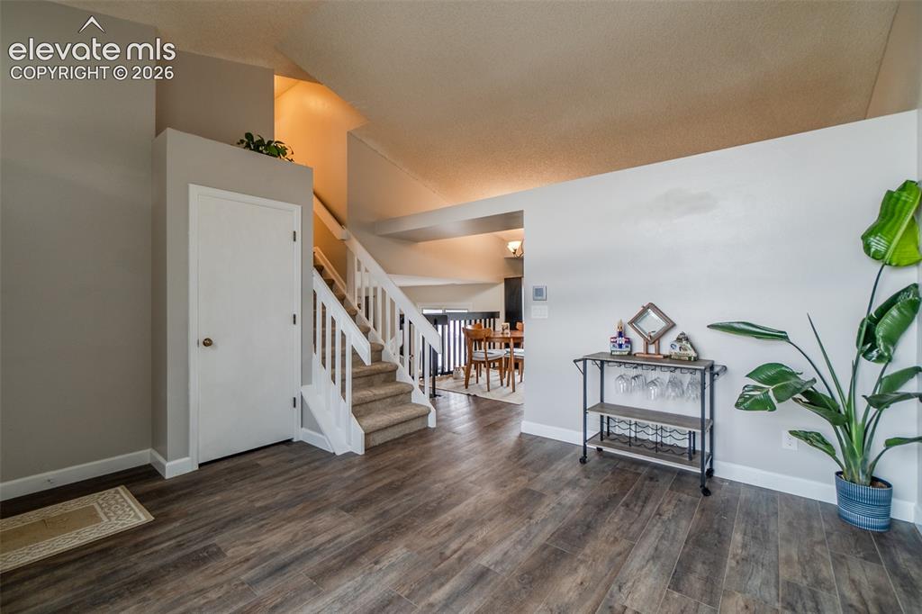 Image 4 of 31: Living Room with hall closet and stairs to the bedrooms, see above for deco