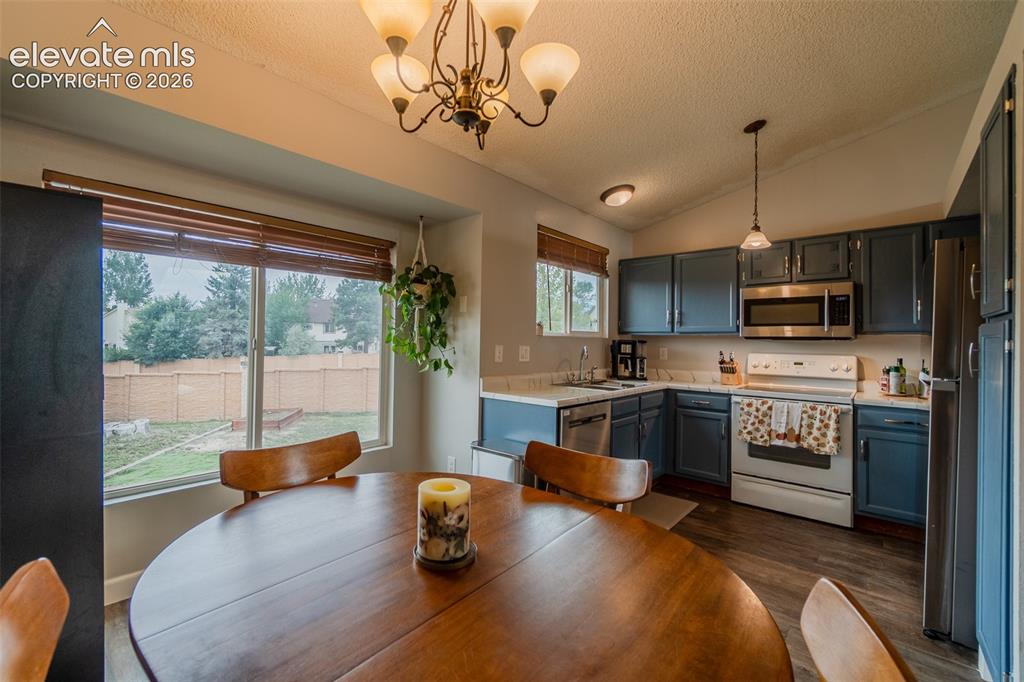 Image 6 of 31: Kitchen featuring wood-finish flooring, white countertops, blue cabinetry, 