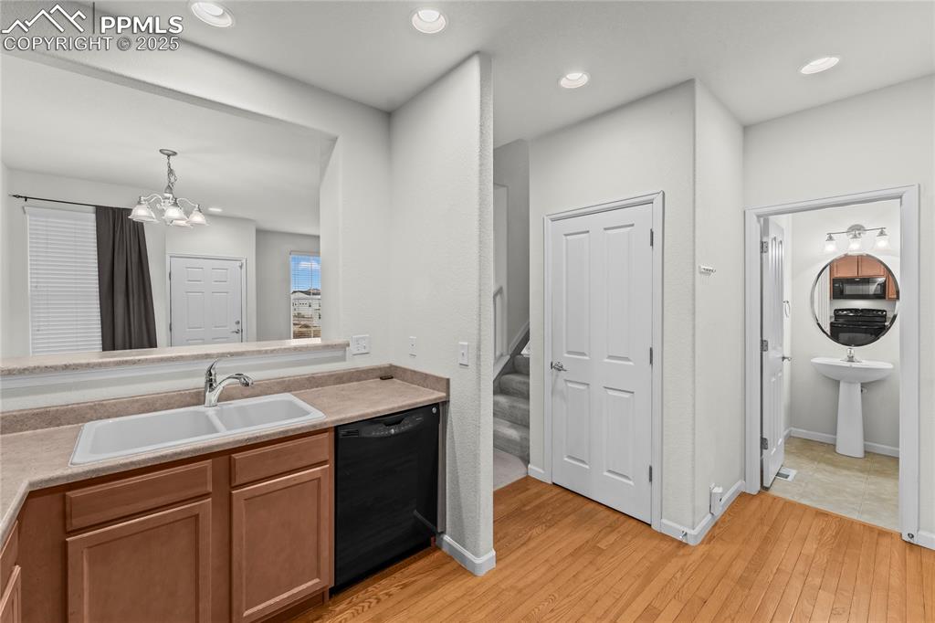 Image 11 of 26: Kitchen featuring black appliances, light countertops, hanging light fixtur