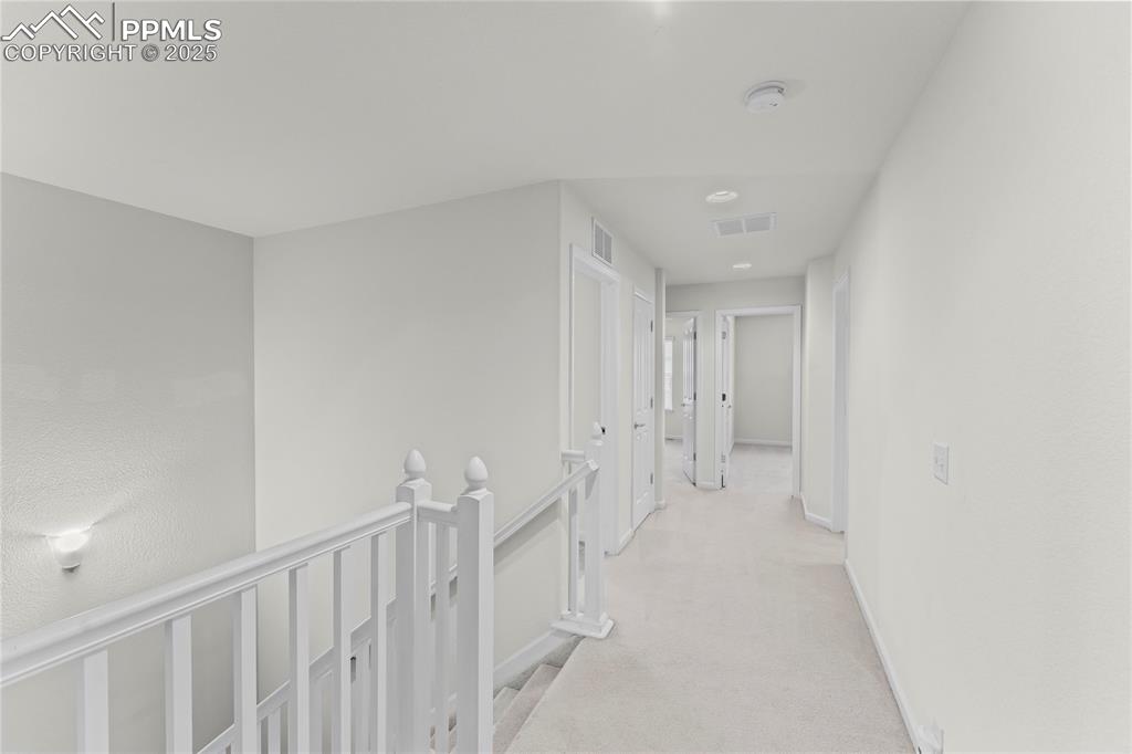 Image 13 of 26: Hallway featuring an upstairs landing, light colored carpet, and recessed l