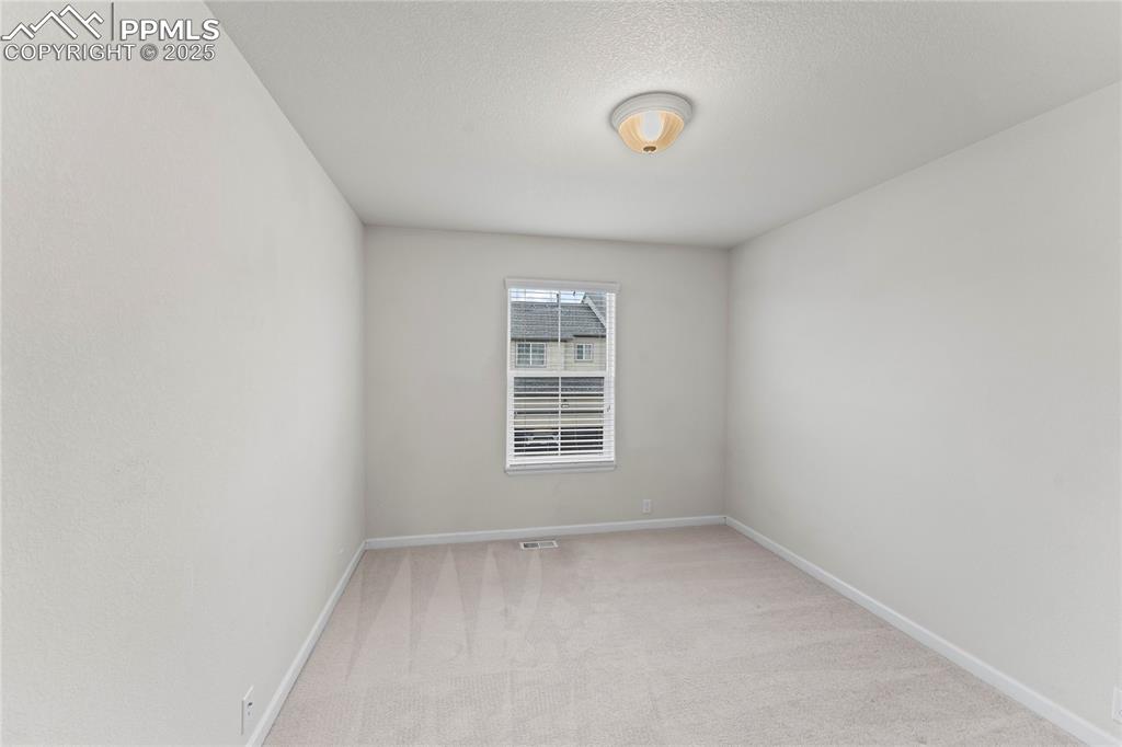Image 20 of 26: Empty room featuring light carpet and a textured ceiling