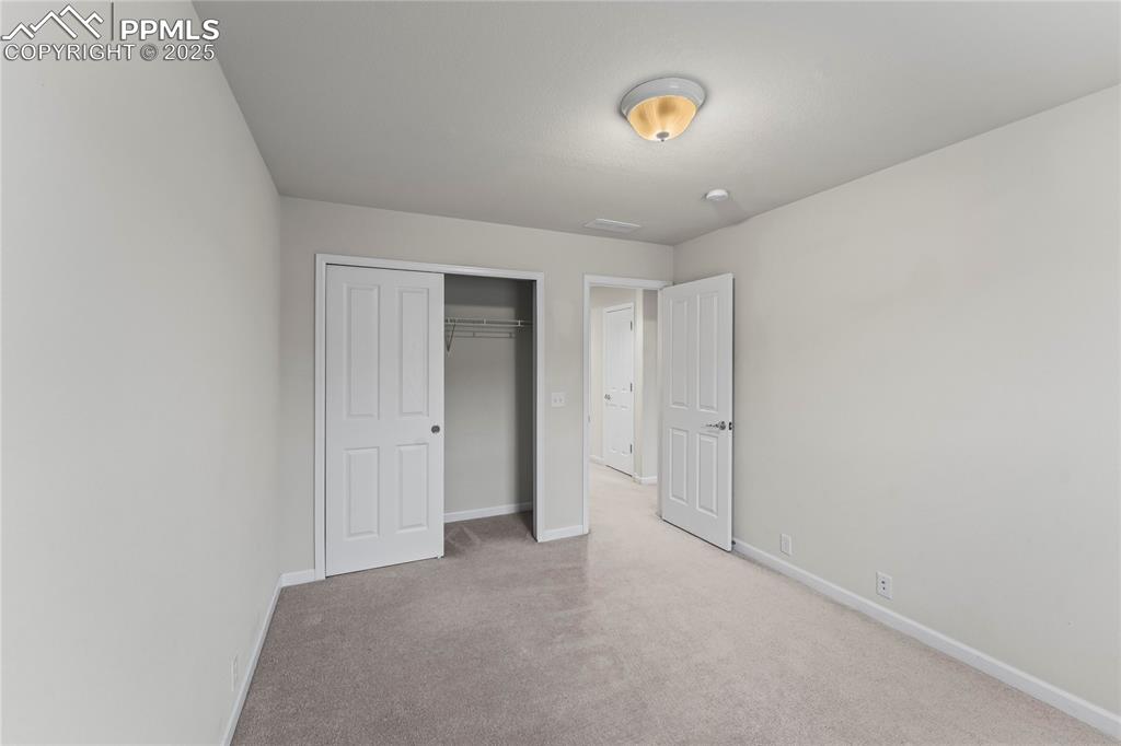 Image 21 of 26: Unfurnished bedroom featuring light colored carpet and a closet