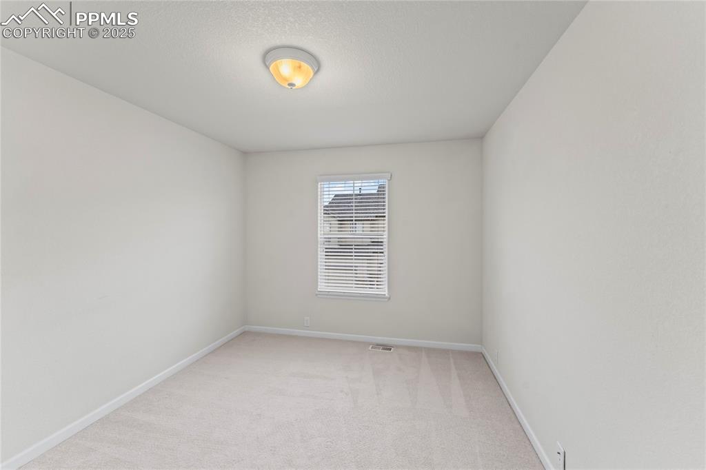 Image 22 of 26: Unfurnished room with light carpet and a textured ceiling