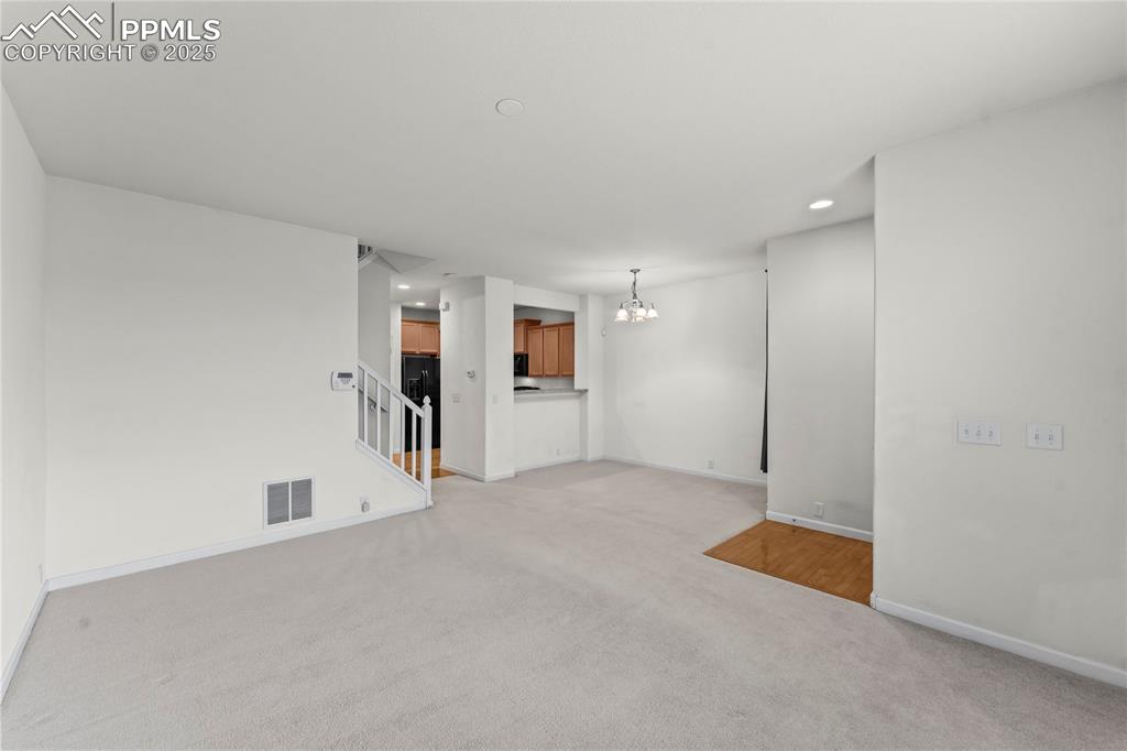 Image 7 of 26: Unfurnished living room with a chandelier, recessed lighting, and light col