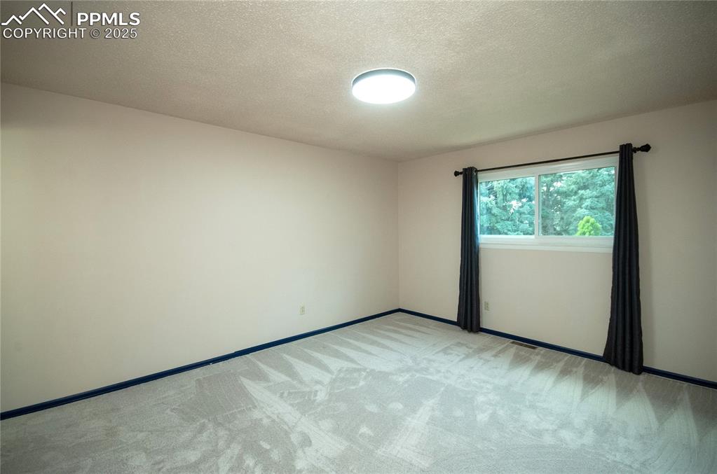 Image 13 of 42: Unfurnished room with light colored carpet and a textured ceiling