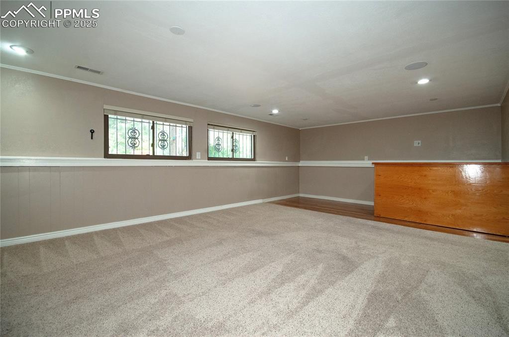Image 18 of 42: Spare room with crown molding, carpet, and recessed lighting