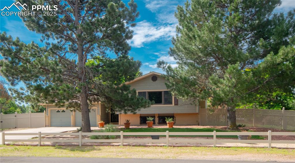 Image 2 of 42: View of front of property with concrete driveway, an attached garage, brick