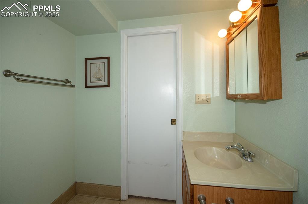 Image 21 of 42: Bathroom with vanity and tile patterned flooring