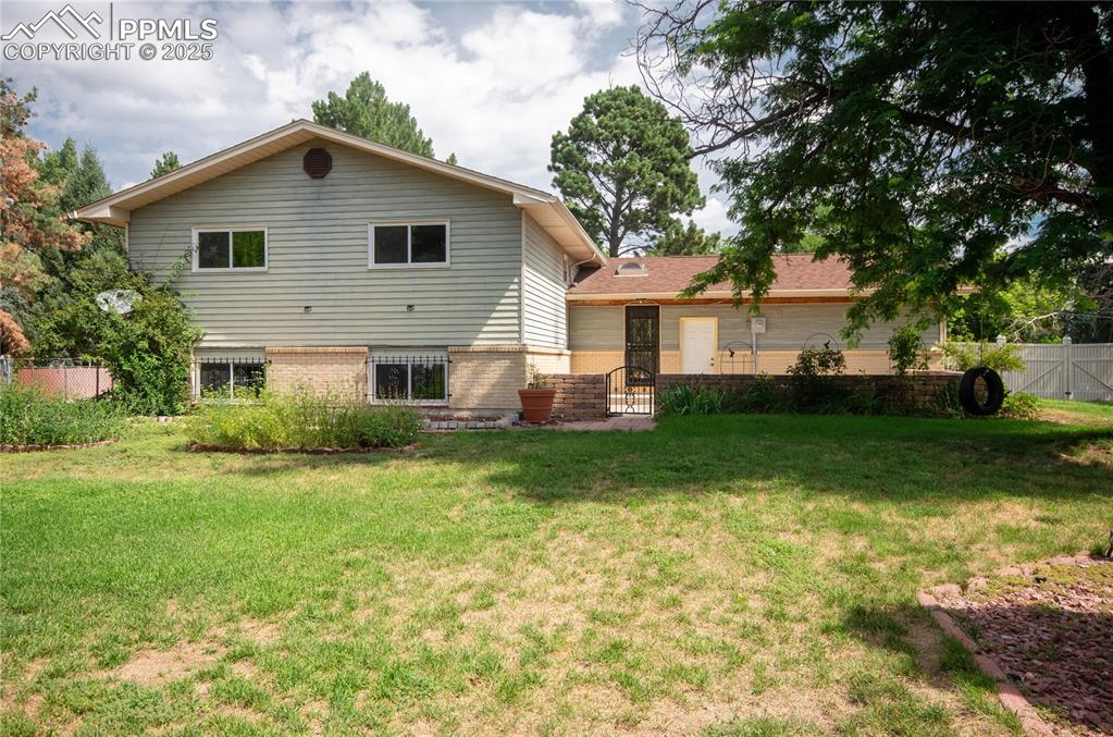 Image 24 of 42: Rear view of property with brick siding and a gate
