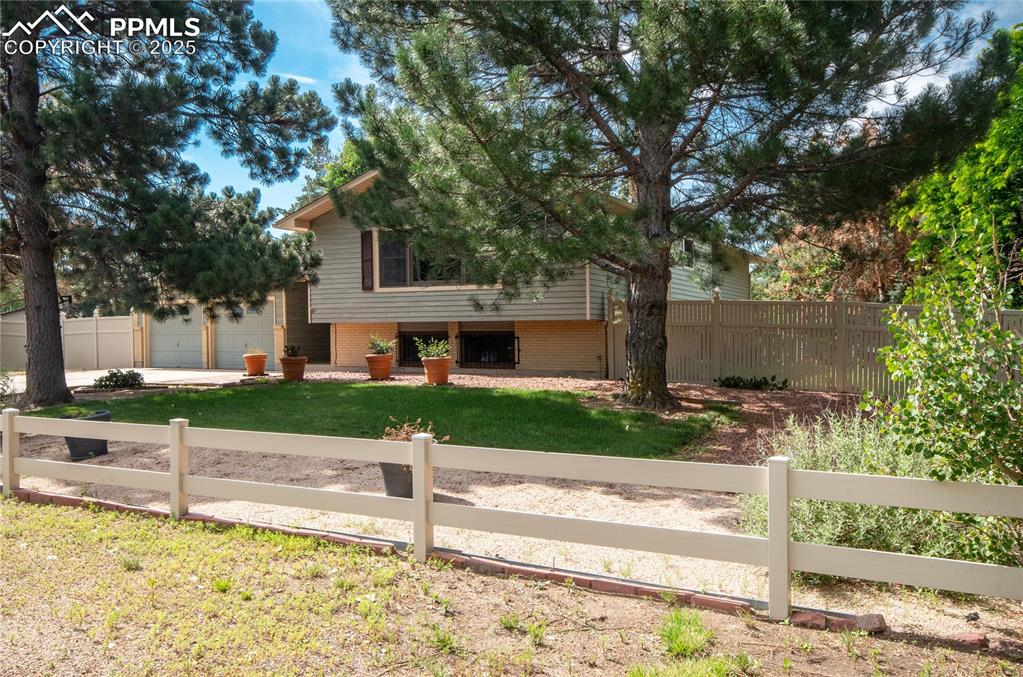 Image 3 of 42: View of front of property featuring a fenced front yard, a garage, brick si