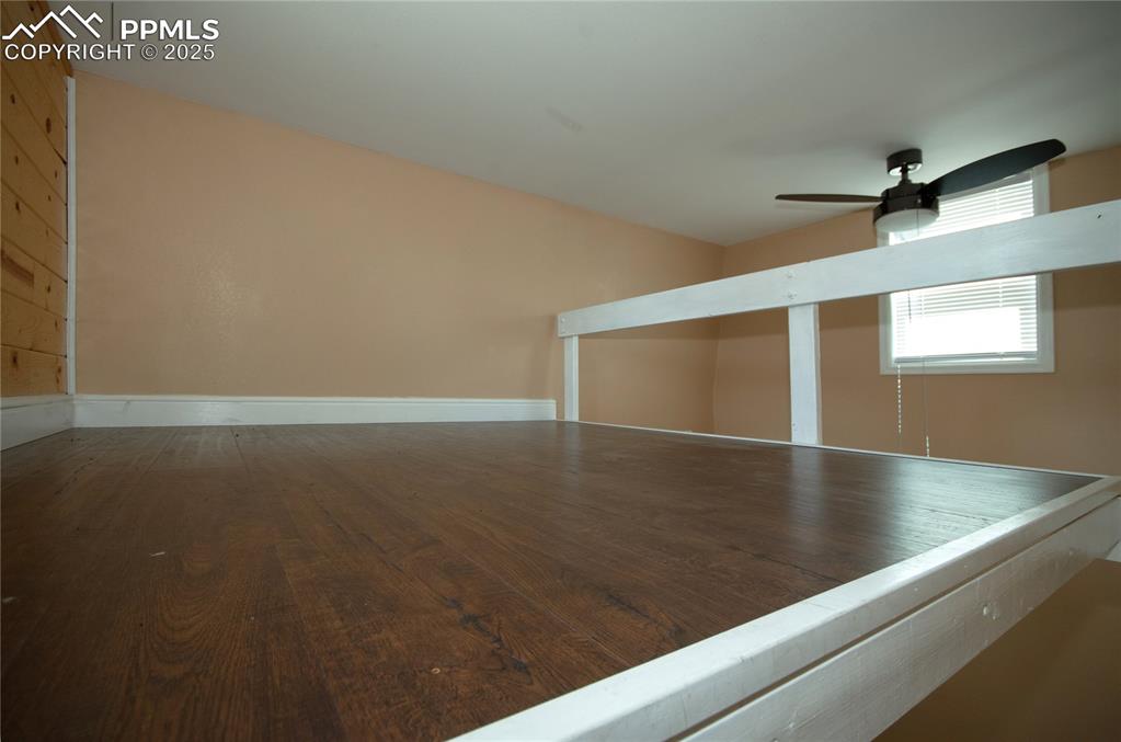 Image 40 of 42: Empty room with ceiling fan and wood finished floors