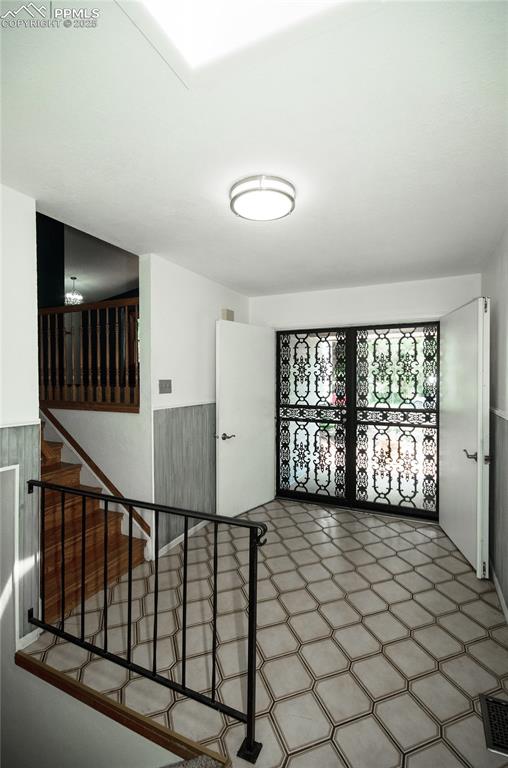 Image 7 of 42: Spare room with tile patterned floors and stairway