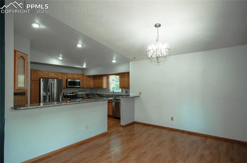 Image 9 of 42: Kitchen featuring vaulted ceiling, appliances with stainless steel finishes