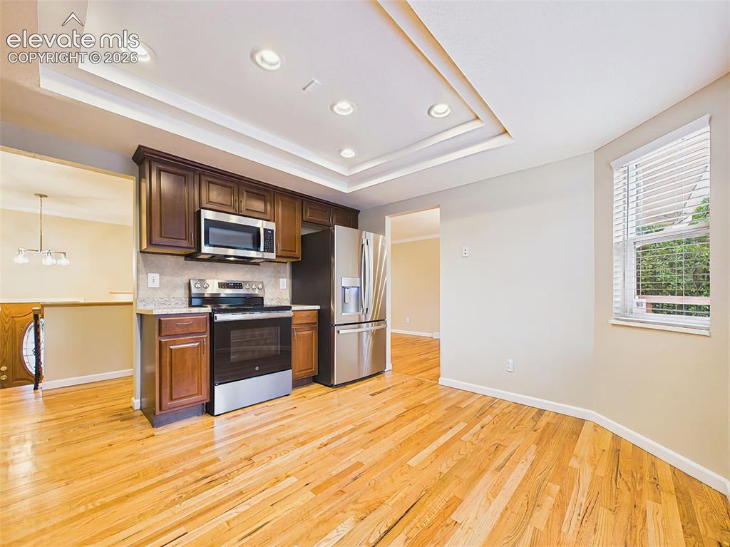 Image 11 of 50: Bright eat-in kitchen featuring rich wood cabinetry, durable laminate count