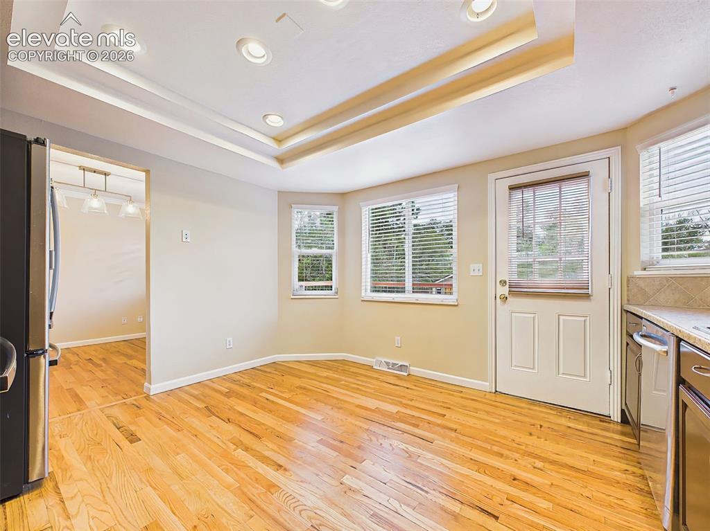 Image 14 of 50: The open kitchen features hardwood flooring, rich wood cabinetry, stainless