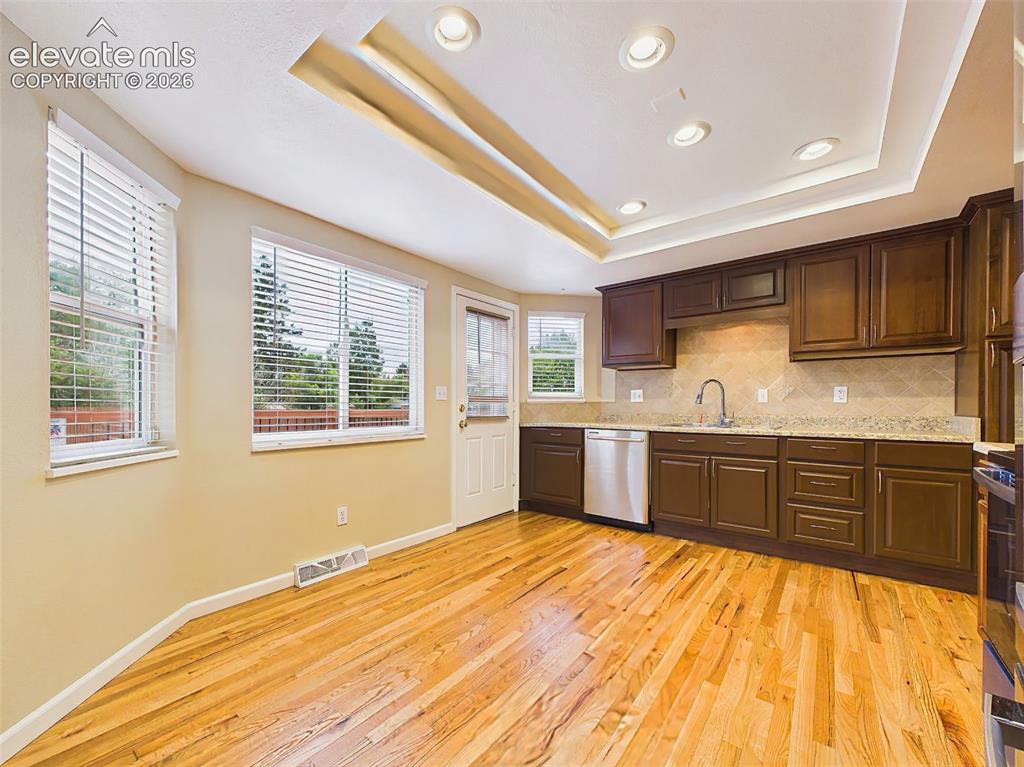 Image 15 of 50: Formal dining room with contemporary lighting and hardwood flooring, seamle