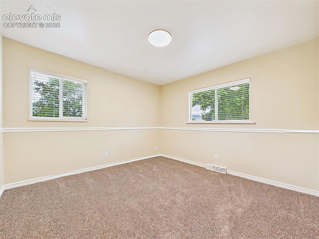 Image 24 of 50: Bright and comfortable secondary bedroom with brand-new carpet, large windo