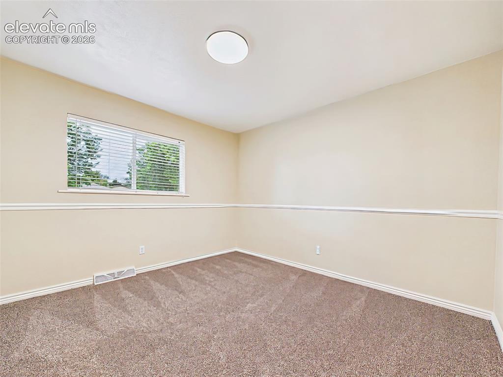 Image 26 of 50: Spacious secondary bedroom featuring brand-new carpet, a large picture wind