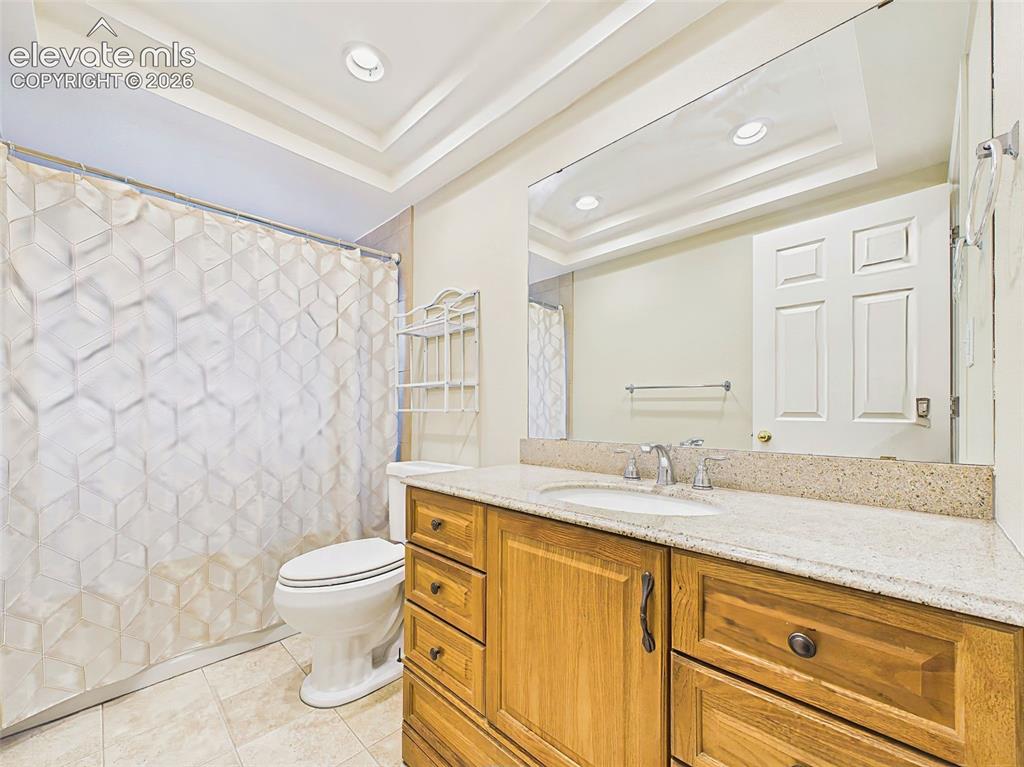 Image 27 of 50: Full hall bath with a granite-topped vanity, updated lighting, and a tub/sh