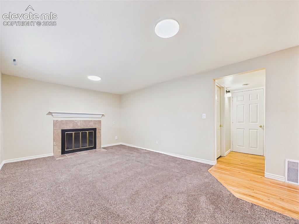 Image 30 of 50: Family Room – Spacious lower-level family room featuring brand-new carpet,